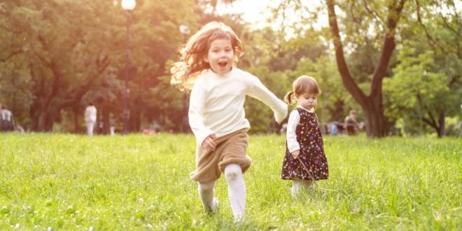Young girls running and playing in a sunny field